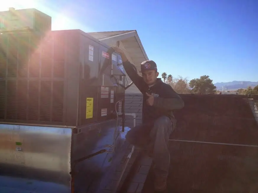 HVAC technician performing HVAC Inspection on a rooftop unit in Excelsior Springs